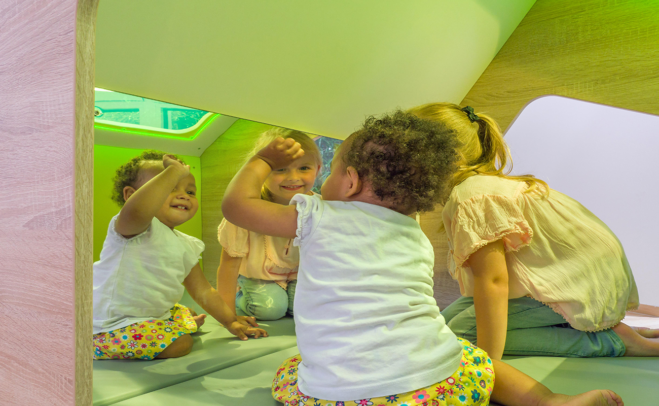 EduCasa Spielhaus Sinne Innenansicht mit Spiegel und grünem Plexiglasdach