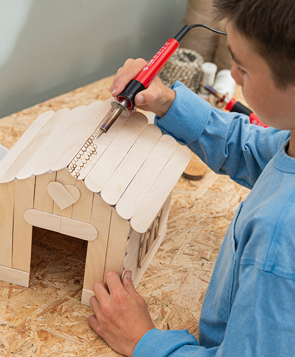 Schüler arbeitet mit Holzbrennset