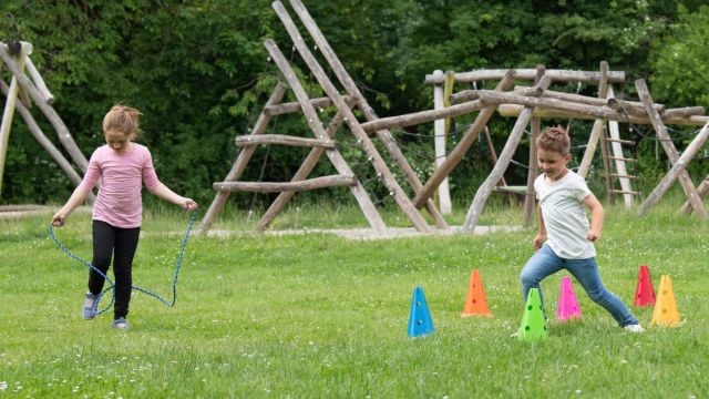 zwei Kinder spielen auf einer Wiese