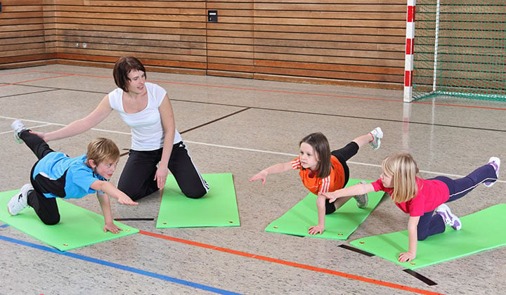 Lehrerin mit Kindern im Sportunterricht