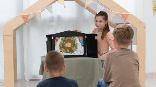 Mädchen erzählt dem Publikum mit dem Kombi-Kamishibai eine Geschichte