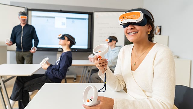 Schülerin trägt das VR-Headset und hält beide Controller in der Hand