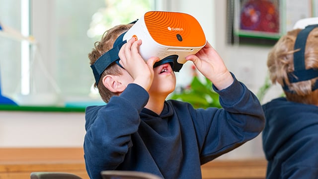Kind hat die VR-Brille auf und schaut erstaunt