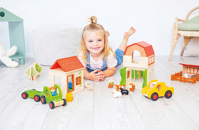 Baby & Kleinkind Kleinkind spielt mit Holzspielzeug auf dem Boden