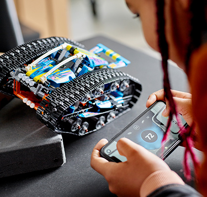 Mädchen steuert LEGO® Technic Transformationsfahrzeug mit Smartphone